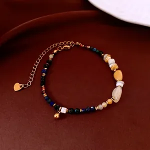 Bracelet ethnique en perles de pierre et coquillage avec breloque cœur sur velours rouge