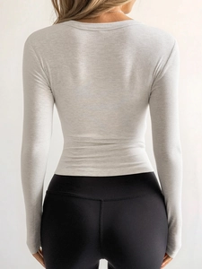 Detail of grey long-sleeve ribbed top with back waist tightening and slim fit design