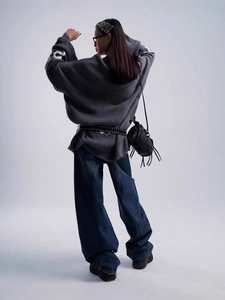 Back view of women's slouchy letter jacquard sweater with loose jeans and crossbody bag