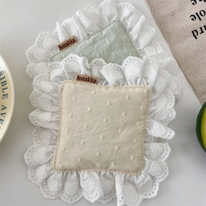 Close-up of cotton linen coaster with scalloped lace edge and Sozakka brand label