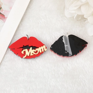 Macro detail of red lip acrylic charm with gold Mom lettering and metal ring attachment