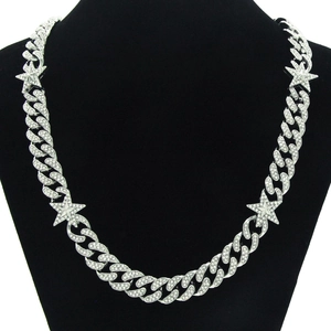 Close-up of iced out silver Cuban chain with star pendant on a black bust mannequin