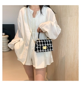 Sac bandoulière en tweed noir et blanc avec chaîne dorée et fermoir pivotant chic