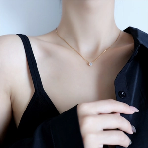 Elegante collana in titanio placcato oro 18K con pendente in zircone 6 griffe su modella