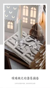Close-up of elegant clear glass T-shaped candle holders on a book for table decor