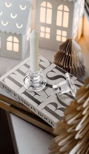 Close-up of elegant clear glass T-shaped candle holders on a book for table decor