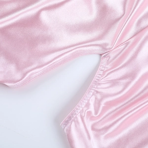 Détail d'une robe en satin rose montrant des coutures de qualité et une texture lisse