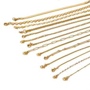 Collection of golden stainless steel snake and figaro chains with lobster clasps on white