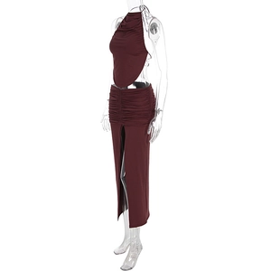 Detail of wine red ruched maxi skirt with high slit and backless halter top set