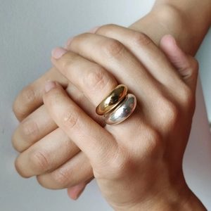Macro shot of minimalist gold and silver dome rings showing polished metal texture