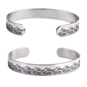 Detailed view of silver stainless steel cuff bangle with traditional ocean wave patterns