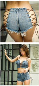 Detailansicht des Denim-Sets mit geschnürtem Crop-Top und ausgefransten Mini-Shorts