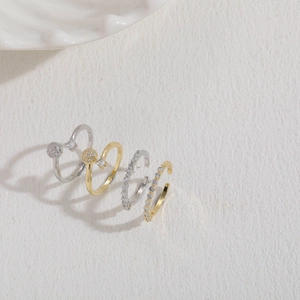 Four-piece stackable ring set with cubic zirconia cross and geometric bypass designs