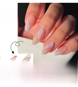 Detail of long almond press-on nails with blue purple waves and silver glitter accents