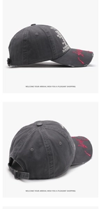 Detail view of cotton baseball cap with white letter print and red brim embroidery