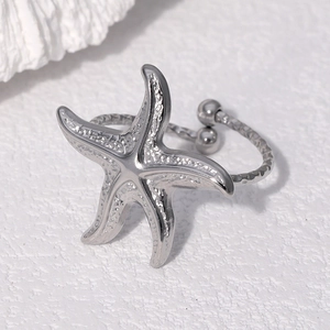 Macro shot of silver starfish ring featuring a textured hammered metal surface