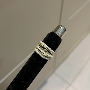 Detail of vintage square pearl beaded rings in gold finish stacked on display