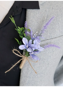 Dettaglio di un fiore all'occhiello viola con lavanda e spago su blazer grigio
