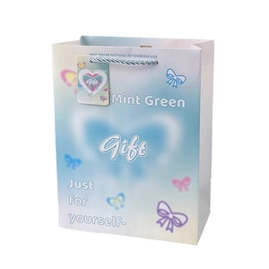 Gradient blue and pink embossed gift bag with butterfly patterns and a ribbon bow handle