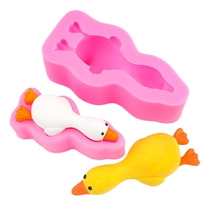 Pink silicone duck mold for DIY desserts with white and yellow finished ducklings