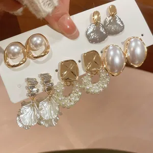 Close-up of pearl and diamond petal earring set in elegant gold and champagne tones