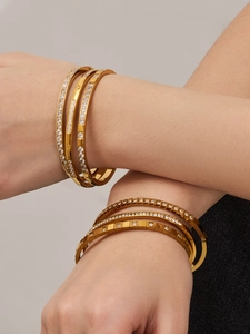 Dettaglio del set di bracciali in acciaio dorato con zirconi 5A e dettagli geometrici