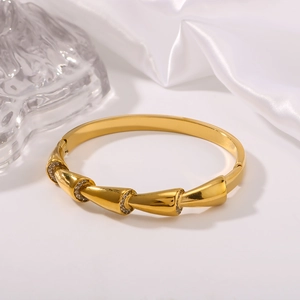 Eleganter Gold-Bambus-Armreif für Damen mit Pavé-Diamanten auf einem Seidenhintergrund