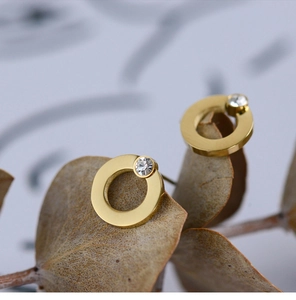 Macro shot of 18K gold plated geometric hoop earrings with a sparkling zircon inlay