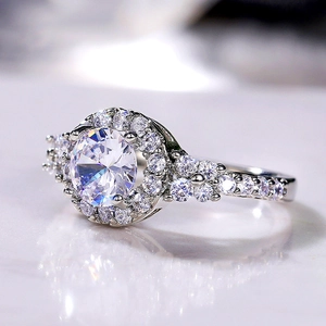 Macro shot of a halo-set round zircon ring with small diamonds on a marble background