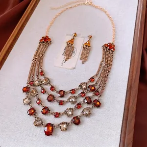 Vintage gold triangle jewelry set with amber stones and layered necklace on satin