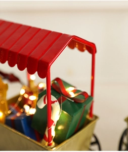 Gros plan d'un chariot de Noël miniature avec cadeaux colorés et cannes de sucre festives