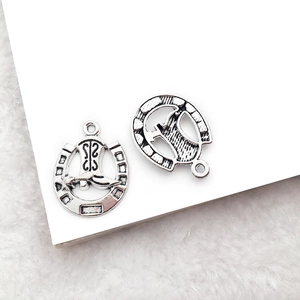 Macro view of vintage silver horseshoe and cowboy boot charms for DIY jewelry making