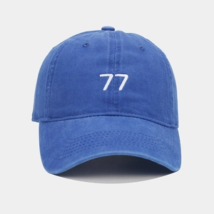 Gros plan sur la broderie du chiffre 77 blanc sur une casquette vintage bleu roi