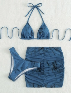 Flat lay of navy marble print mesh three-piece bikini set with ruched sarong skirt