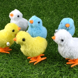 Detailed view of colorful plush wind-up chickens on green grass for kids play