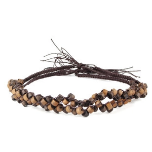 Detail of handcrafted woven hemp rope with brown wooden beads and retro bull head pendant