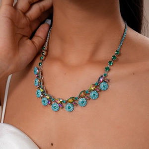 Close-up of vintage statement necklace with blue and green gems on female model