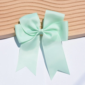 Detail of 6-inch mint green ribbed ribbon hair bow with fishtail streamers and soft shadow