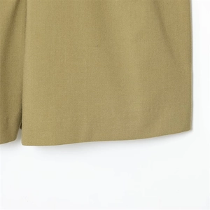 Detailed macro shot of khaki twill cotton fabric texture and precise stitching on the hem