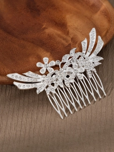 Makroaufnahme von silbernem Braut-Haarkamm mit Strass und Blumendetails auf Holz