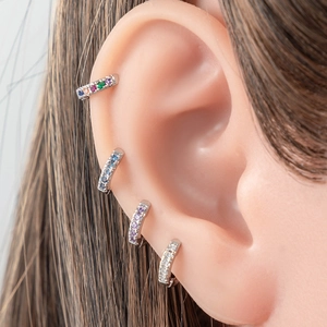 Mini copper zircon hoop earrings with rainbow, blue, purple, and white stones on ear