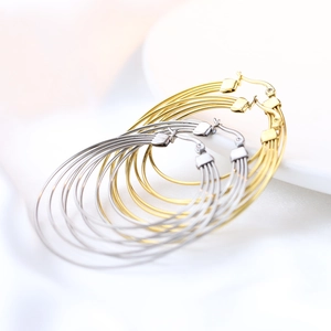 Detail view of 50mm layered gold and silver stainless steel hoop earrings on white silk