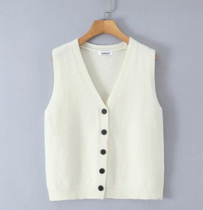 Close-up of a white knit V-neck vest featuring high-quality dark buttons and branding label