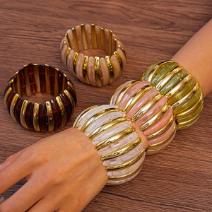 Close-up of colorful chunky acrylic stretch bracelets with gold-tone metal spacers