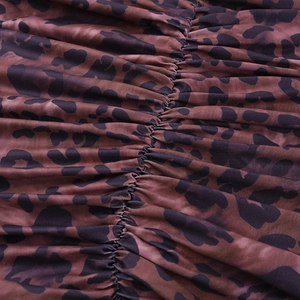Detail of leopard print dress featuring sexy V-neckline and ruched fabric texture