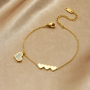Polished gold-plated stainless steel heart bracelet with pave zircon charms on satin