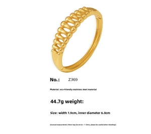Detail view of gold-plated stainless steel cuff featuring a hollowed herringbone pattern