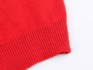 Detailed macro view of the premium red knit fabric with ribbed cuff textures
