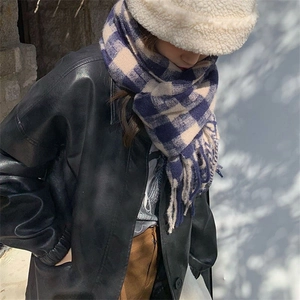 Close-up of blue and white plaid tassel scarf paired with white faux fur bucket hat