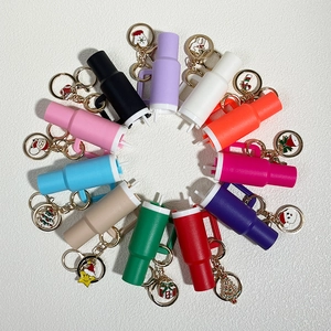 Set of 12 colorful mini tumbler keychains with festive Christmas charms on white background